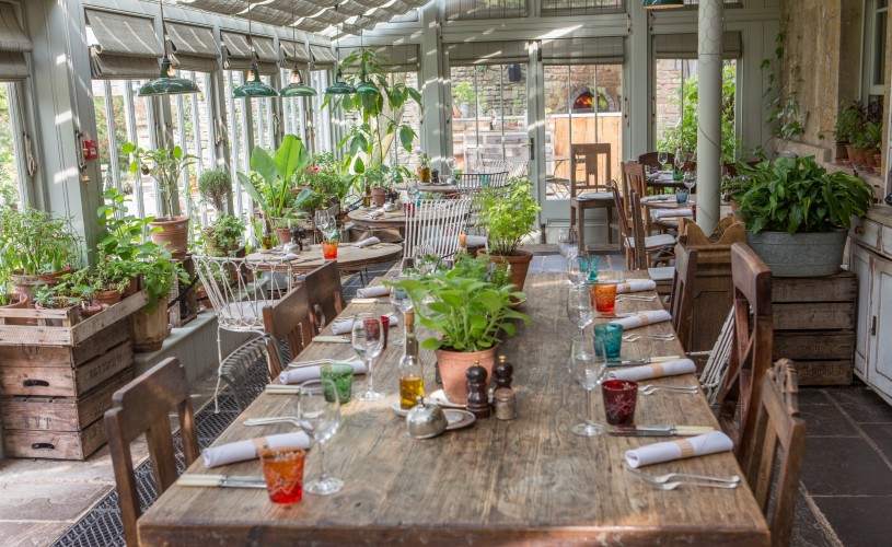 Dining tables and plants in The Garden Restaurant at The Pig-Near Bath